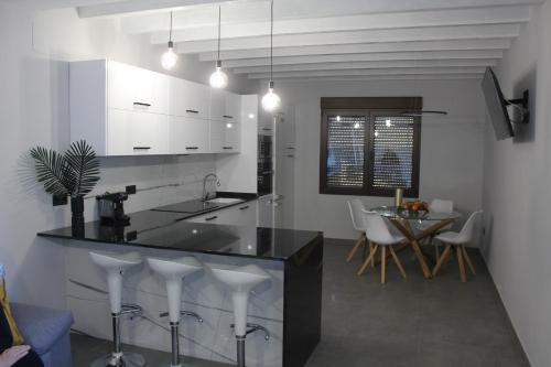 a kitchen with a black counter and white cabinets at CASA RURAL MENSIN in Villar de Canes
