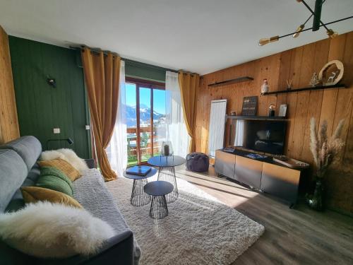 a living room with a couch and a tv at STUDIO - ROCHES ROUSSES b in Orcières