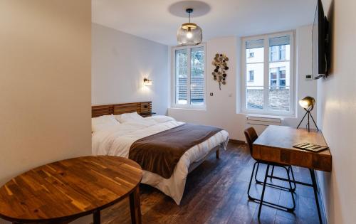 sypialnia z łóżkiem, stołem i biurkiem w obiekcie Brasserie de L ouest w mieście Chartres