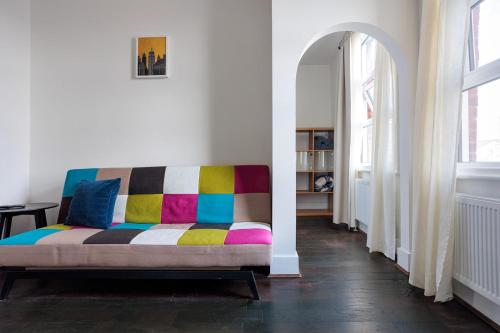 a colorful couch in a room with an archway at Entire luxurious flat sleeps 4 persons in London