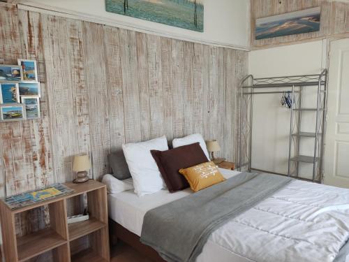 グジャン・メストラにあるLes Cigales du Bassinのベッドルーム1室(白いシーツと茶色の枕が備わるベッド1台付)