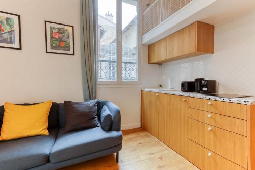 un salon avec un canapé et une cuisine dans l'établissement Les Cottages de Montmartre - Secret Courtyard, à Paris