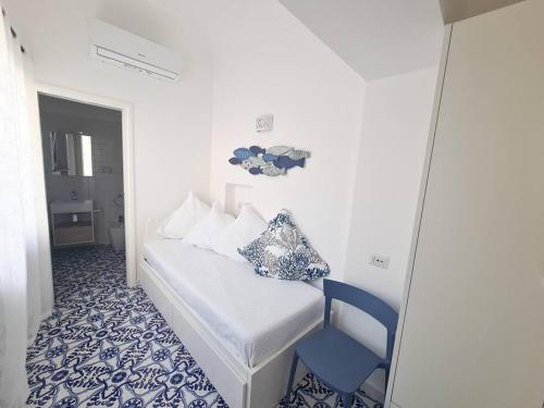 - une chambre avec un lit et une chaise bleue dans l'établissement La Chiocciola, à Capri