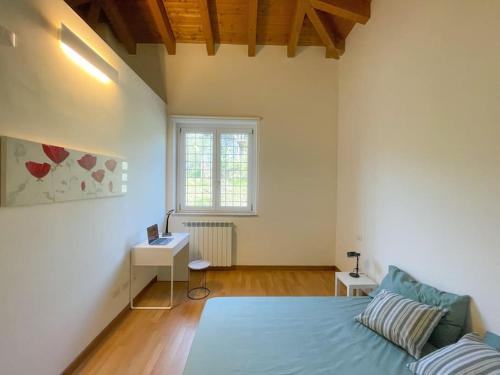 a bedroom with a bed and a desk and a window at Dimora il Fontanile in Castel di Guido