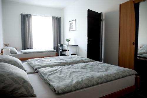 een slaapkamer met 2 bedden en een raam bij Apartman ERIK in Požega