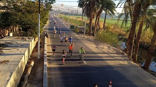 a group of people running on a road at Habou City Apartment in Luxor