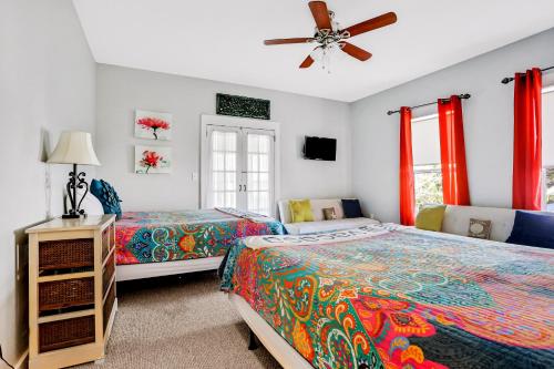 a bedroom with two beds and a ceiling fan at Breaking Winds in Port Saint Joe