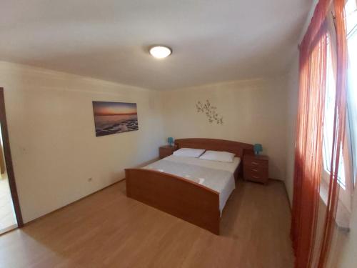 ein kleines Schlafzimmer mit einem Bett und einem Fenster in der Unterkunft Apartments Elvir Nin in Nin