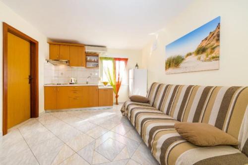 ein Wohnzimmer mit Couch und Küche in der Unterkunft Apartments Elvir Nin in Nin