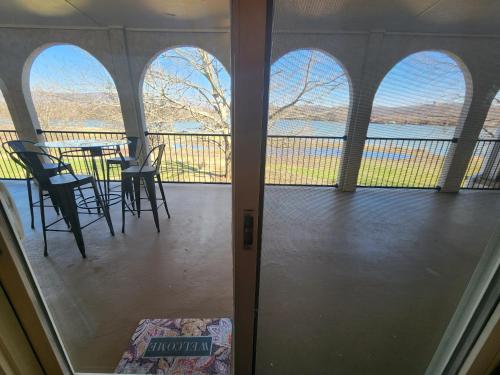 a balcony with a table and chairs and a view of the water at Signal Mountain Room at Tennessee RiverPlace in Chattanooga