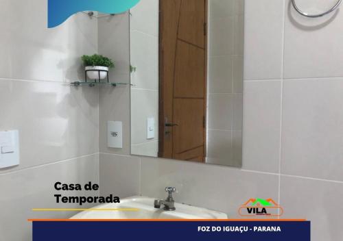 y baño con lavabo y espejo. en Casa maravilhosa c/piscina bourb, en Foz do Iguaçu