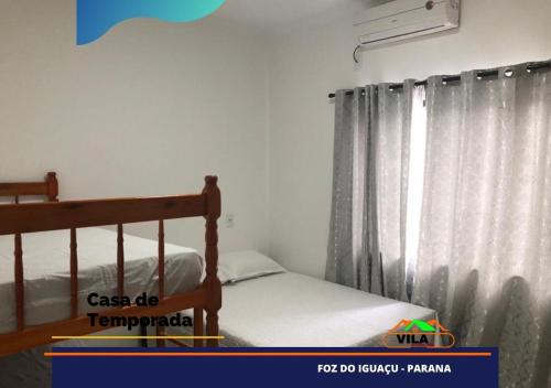 1 dormitorio con 1 cama y una ventana con cortinas en Casa maravilhosa c/piscina bourb, en Foz do Iguaçu