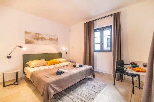 een slaapkamer met een bed, een bureau en een raam bij Villa Prodol by Villa Plus in Manjadvorci