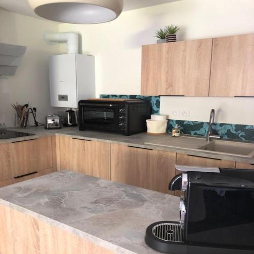 a kitchen with a sink and a microwave at Azurea - Charmant appartement à Andernos-les-Bains in Andernos-les-Bains