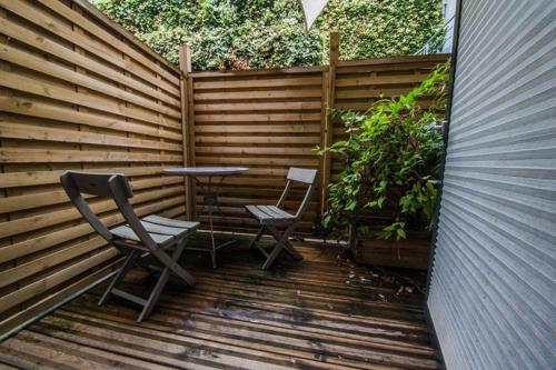 a patio with a table and two chairs and a fence at Guesthouse Le Vauban in Neuf-Brisach