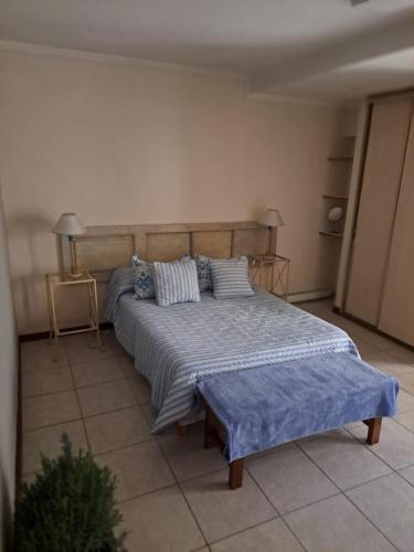 1 dormitorio con 1 cama con sábanas y almohadas azules en Leonidas apartments en Mendoza