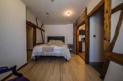 a bedroom with a bed and a wooden floor at Guesthouse Le Vauban in Neuf-Brisach