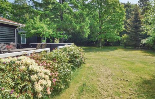 a yard with a house with a fence and flowers at Two-Bedroom Holiday Home In Kalundborg in Kalundborg