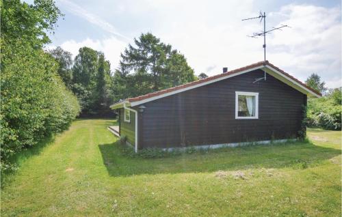 a small house in a field with a grass yard at Two-Bedroom Holiday Home In Kalundborg in Kalundborg