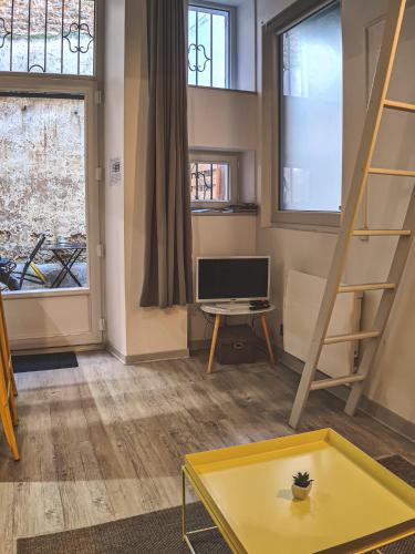 a living room with a yellow table and a tv at Yellow Studio - Poitiers Coeur de ville in Poitiers