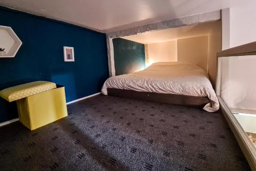 niewielka sypialnia z łóżkiem i żółtym krzesłem w obiekcie Yellow Studio - Poitiers Coeur de ville w mieście Poitiers