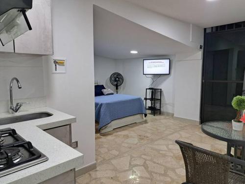 una cocina y un dormitorio con una cama en una habitación en Laureles 001, en Medellín