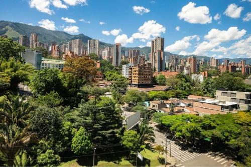un paisaje urbano de una ciudad con altos edificios y árboles en Laureles 001, en Medellín