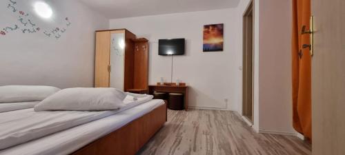 a bedroom with a bed and a tv on the wall at Vila Luna Predeal in Predeal