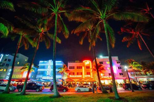 a group of palm trees in a city at night at Lush tropical big home close to Airport, Calle 8, Coral Gables and lots more Miami amenities in Miami