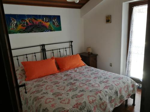 a bedroom with a bed with orange pillows on it at Appartamento Lucia in Pescocostanzo