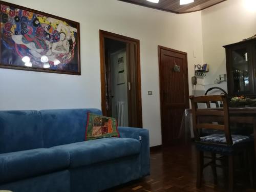 a living room with a blue couch and a chair at Appartamento Lucia in Pescocostanzo