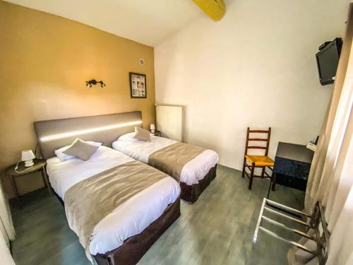 een hotelkamer met 2 bedden en een stoel bij Logis Hotel Restaurant la Corniche des Cevennes in Saint-Jean-du-Gard