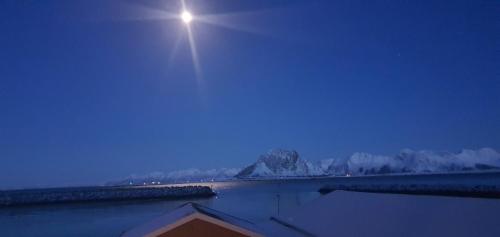 a moonrise over a body of water at night at Lofoten Sunset & Ocean VIew in Valle