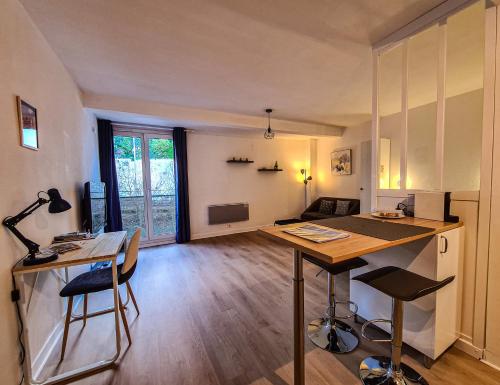 cocina y sala de estar con mesa y sillas en Grand Studio neuf Parking Privatif 3 minutes Gare au calme, en Poitiers