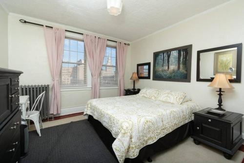 1 dormitorio con 1 cama y una ventana con cortinas rosas en The Traveler Suite C1 en Hartford