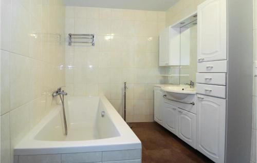 La salle de bains blanche est pourvue d'une baignoire et d'un lavabo. dans l'établissement 3 Bedroom Cozy Apartment In Vodernberg, à Vordernberg