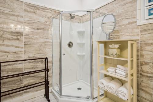 La salle de bains est pourvue d'une douche avec une porte en verre. dans l'établissement A Beach Spot, à Galveston