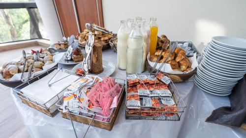 een buffet met eten op een tafel met borden bij Los Espinillos Hotel y Spa in Villa Carlos Paz