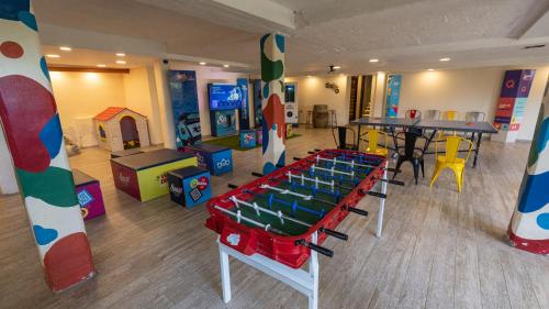 una habitación con 2 mesas y una sala de juegos en Los Espinillos Hotel y Spa en Villa Carlos Paz