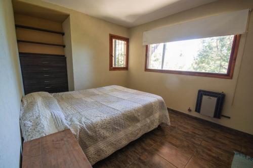 1 dormitorio con cama y ventana en casa con vista al lago en San Carlos de Bariloche