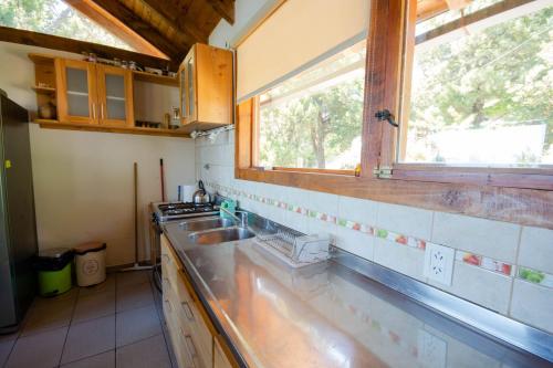 cocina con fregadero y ventana en casa con vista al lago en San Carlos de Bariloche