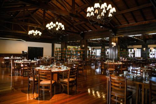 a dining room with tables and chairs and chandeliers at Sanma Hotel in Foz do Iguaçu