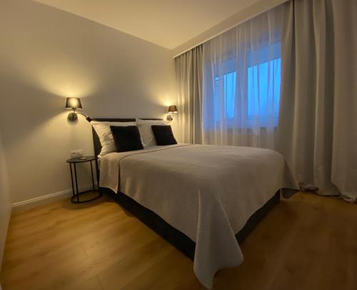 a bedroom with a large bed and a window at Apartament Dekerta winda, duży taras, bezpłatny GARAŻ in Gorzów Wielkopolski