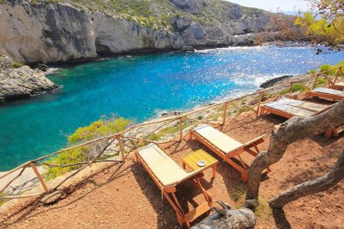 a beach with two chairs and a body of water at Agios Leon Apartment 2 in Agios Leon