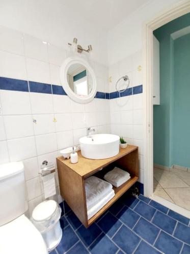 a bathroom with a sink and a toilet and a mirror at Agios Leon Apartment 2 in Agios Leon