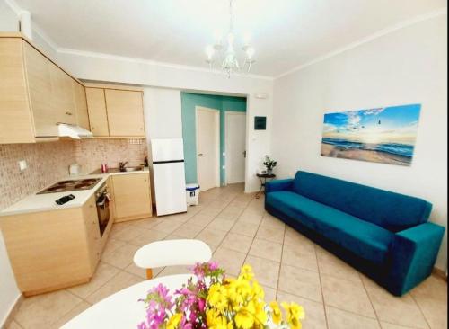 a living room with a blue couch and a kitchen at Agios Leon Apartment 2 in Agios Leon