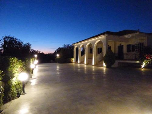 a building with lights in a parking lot at night at Agios Leon Apartment 2 in Agios Leon
