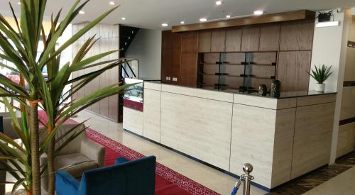 a lobby with a reception desk and a plant at Yan Apartments in Jeddah