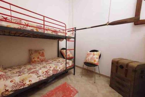 a bedroom with two bunk beds and a chair at Sant Antioco, la vista sulla laguna Q2127 in SantʼAntìoco