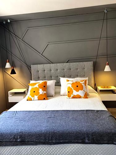 ein Schlafzimmer mit einem großen Bett mit orangefarbenen Kissen in der Unterkunft STUDIO/9 CERRO in Cordoba